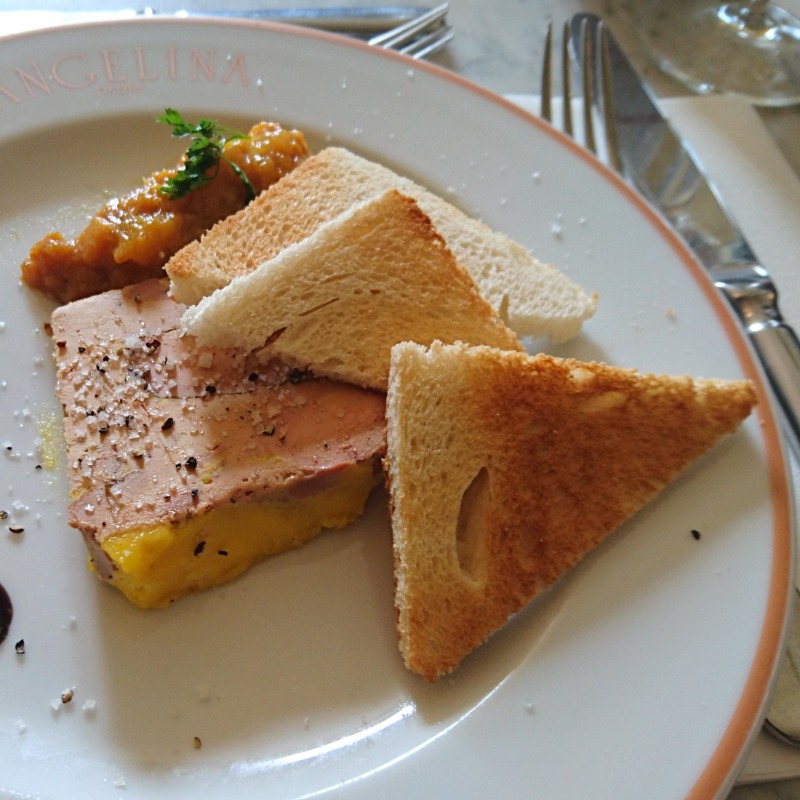 Gänsestopfleber mit Aprikosenkompott auf einem weißen Porzellanteller, dazu Toast.