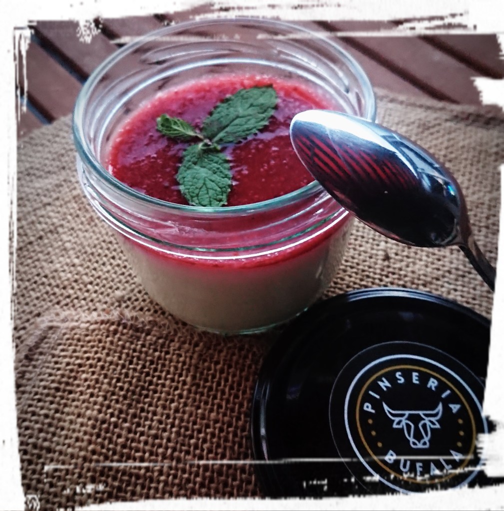 Pana Cotta mit roter Erdbeersoße im Glas mit Schraubdeckel.