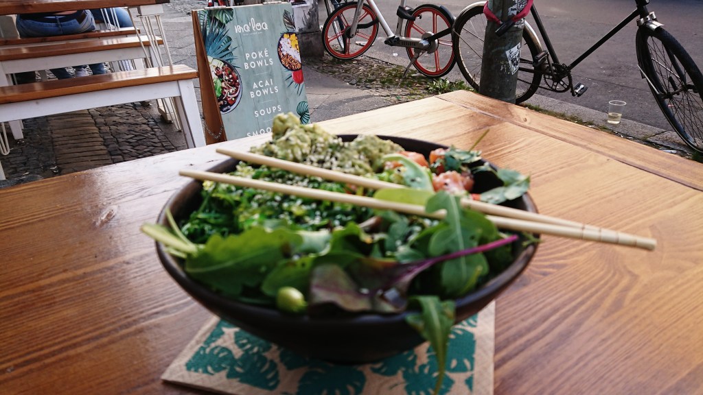 Salat und roher Lachs in einer Schüssel angerichtet.